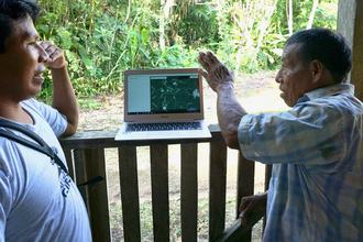 Members of the Waorani Mapping team for Alianza Ceibo, use Mapeo Desktop to consult with an elder Waorani man as part of the Waorani mapping project
