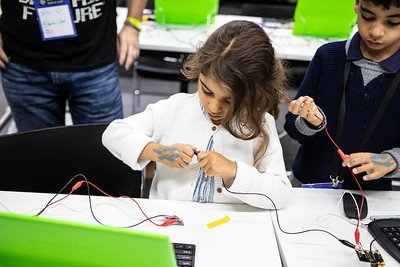 A young child tinkering with technology components