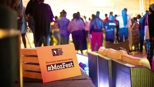 A group of Wranglers, cheering and celebrating outside on grass at MozFest House Kenya.