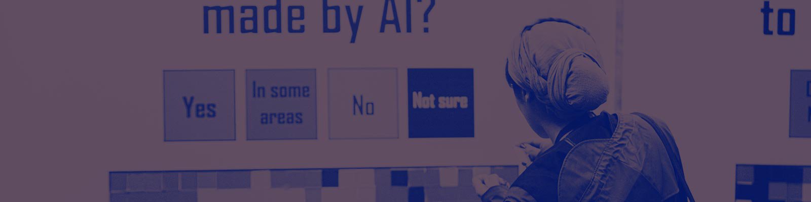 A person stands by an installation at MozFest with the title 'Would you trust decisions made by AI' with people adding red, yellow and green stickers depending on their level of trust.