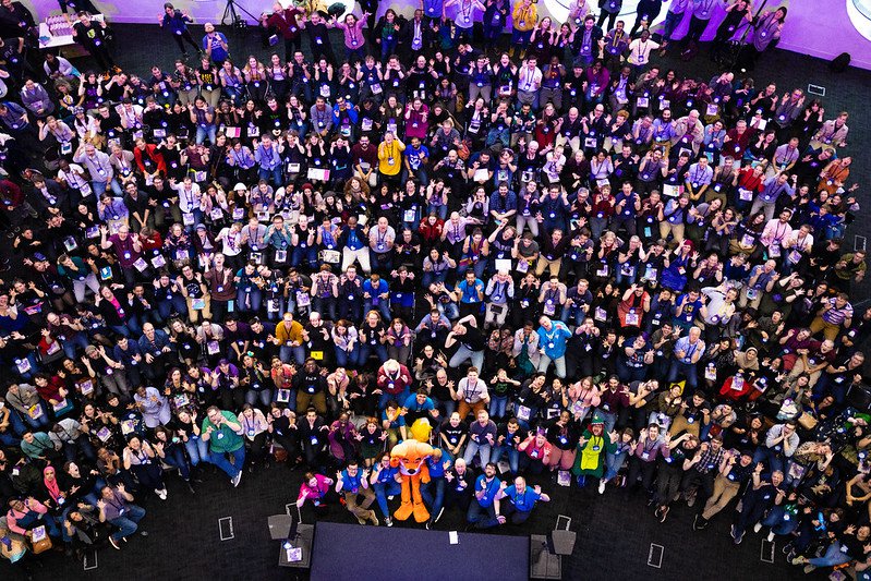 a large group of people, from above, sitting on chairs