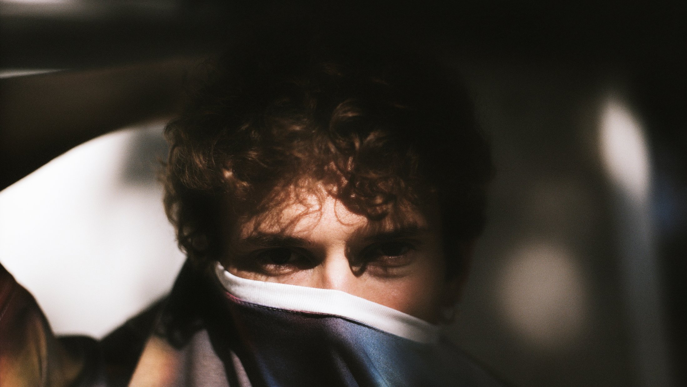 A young man wearing Cap_able design's AI Camo t-shirt, designed to shield the wearer from facial recognition.