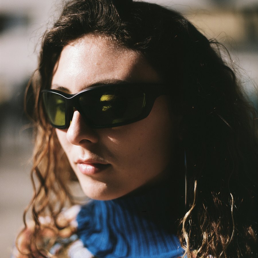 Model wears glasses from Reflectacles, designed to defeat facial recognition systems.