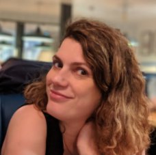 Person smiling at the camera with long, wavy light brown hair