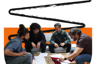 Group of four people collaborating to build an object during a workshop
