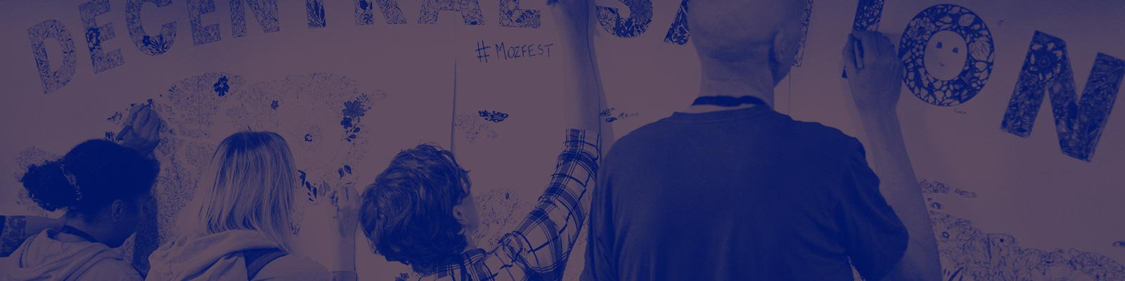 A group of participants at MozFest colouring in a map of the world with the title 'Decentralisation'