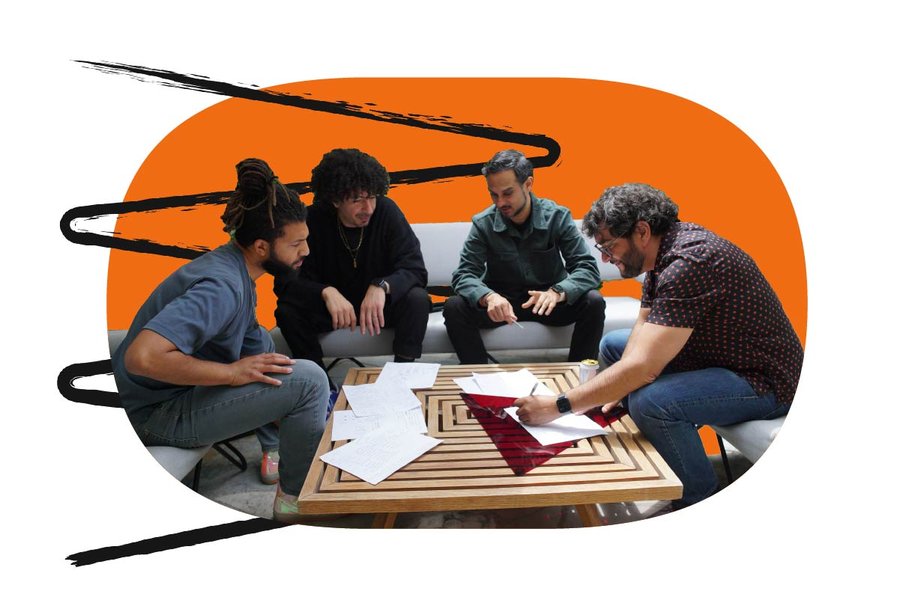 Group of four people looking at some papers on a table on top of an orange shape along with an animated hand drawn zig zag squiggle
