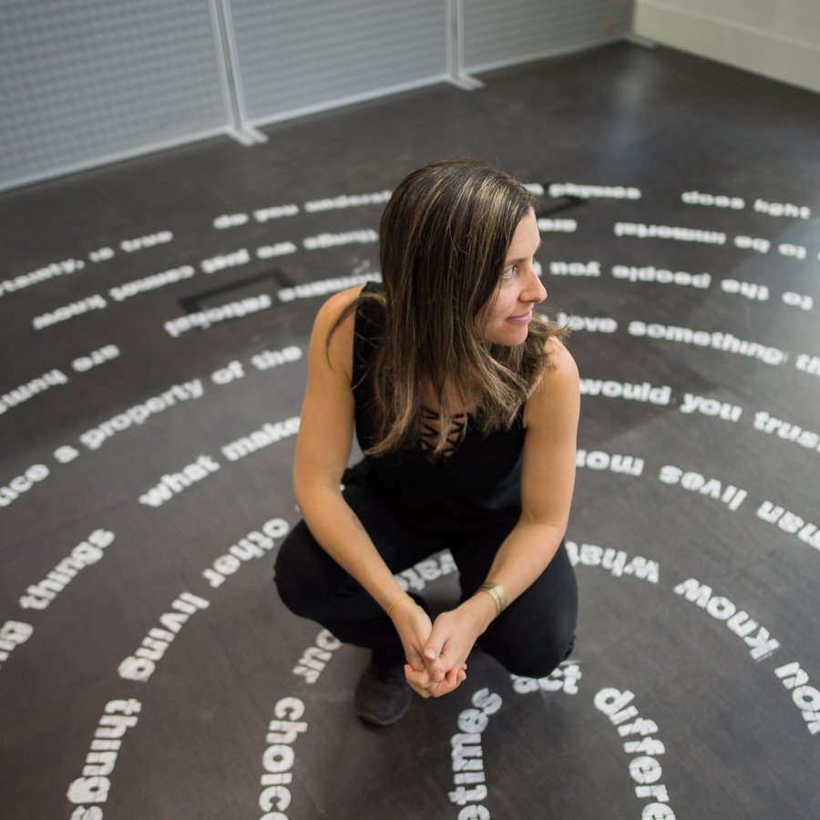A person standing inside of an art installation consisting of circles of text
