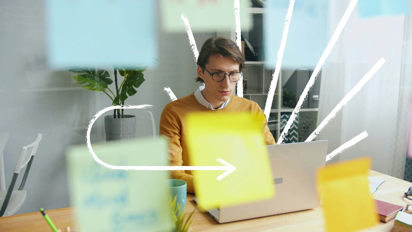 Man with glasses looking at laptop in an office with white hand drawn lines emanating from behind him and an arrow pointing to the laptop
